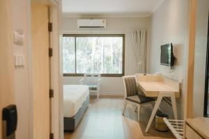 a hotel room with a bed and a desk and a window at The Park Hotel in Phitsanulok