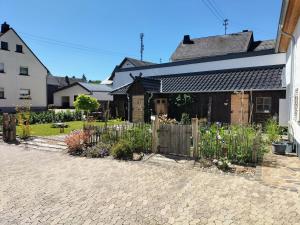 einen Garten vor einem Haus mit einem Zaun in der Unterkunft Ferienwohnung Schneider in Münk