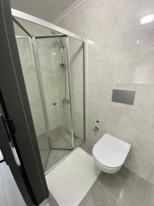 a bathroom with a shower and a white toilet at Kuvvet Villa - 1 in Cimenli