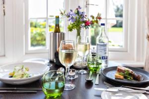 a table with plates of food and wine glasses at Hotel Miramar in Bournemouth