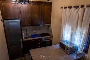 uma cozinha com um frigorífico e um balcão com um micro-ondas em Casa Rural "La Noria" em El Puente