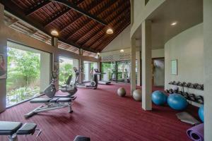 een overdekte fitnessruimte met loopbanden en fitnessapparatuur bij Pattara Resort & Spa in Phitsanulok