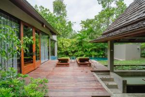 eine Holzterrasse mit zwei Stühlen auf einem Haus in der Unterkunft Pattara Resort & Spa in Phitsanulok