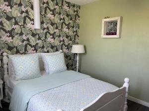 um quarto com uma cama com papel de parede floral em Esprit de campagne 
