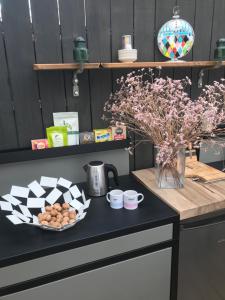 een tafel met een bord eieren en een vaas met bloemen bij Chalet cosy atypique in Vichy