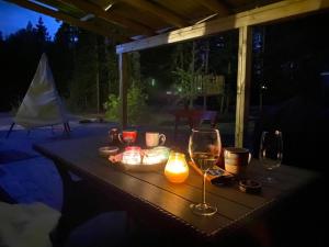 a table with two wine glasses and candles on it at Torp ved Mårbacka (Helt hus til leie) Östra Ämtervik/ Sunne in Östra Ämtervik