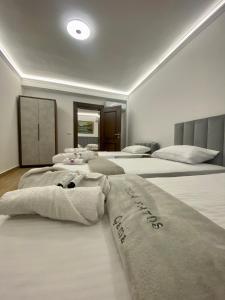 Dos camas en una habitación con toallas. en Vila Fatos Qama en Berat