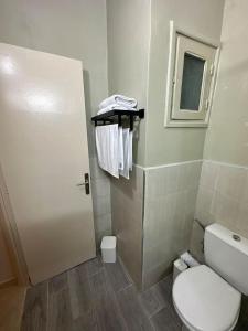 La salle de bains est pourvue de toilettes, d'une fenêtre et de serviettes. dans l'établissement Appartement cosy à Rabat, à Rabat