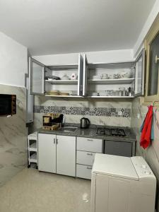 une cuisine avec des placards blancs et un comptoir dans l'établissement Appartement cosy à Rabat, à Rabat