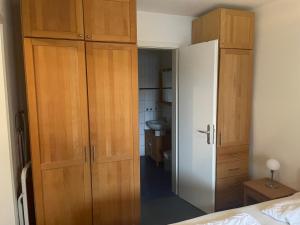 a bedroom with a large wooden cabinet and a bathroom at Seeblick Wohnung 102 mit Ostseeblick in Ostseebad Koserow
