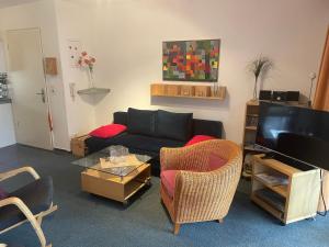 salon z czarną kanapą i krzesłami w obiekcie Seeblick Wohnung 102 mit Ostseeblick w Koserowie