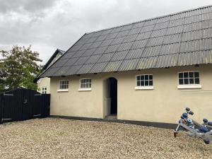 a white house with a black roof at Ørbakke in Græsted