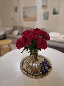 un jarrón lleno de rosas rojas en una mesa en Lovely studio apartment, glazed balcony and own parking space, en Hyvinkää