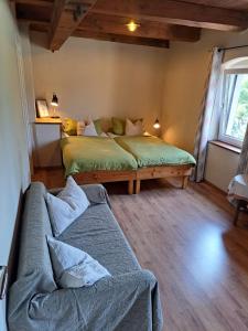 ein Schlafzimmer mit zwei Betten und einem Sofa darin in der Unterkunft Pension Müllers Mühle in Großenhain