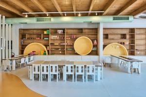 a dining room with tables and chairs and shelves at Stella Palace Aqua Park Resort in Hersonissos