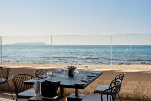 a table with chairs and a view of the ocean at Stella Palace Aqua Park Resort in Hersonissos