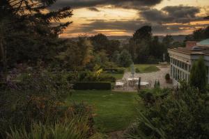 Blick auf den Garten bei Sonnenuntergang mit einem Gebäude in der Unterkunft The Upper House in Stoke on Trent