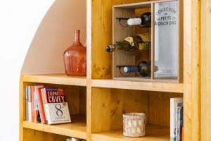 a wooden shelf with wine bottles and books at Casa da Padaria in Évora