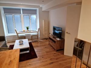 a living room with a couch and a tv and a table at Lovely 1-Bed Apartment in London in London