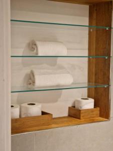 a glass shelf with towels and toilet paper at Lovely 1-Bed Apartment in London in London