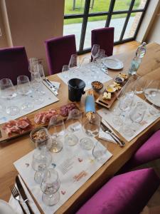 una mesa larga con copas de vino y comida. en Monvì Wine Relais, en Costigliole dʼAsti