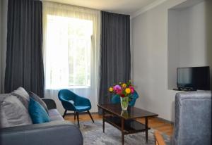 a living room with a couch and a table with flowers at Sunny Lodge Dilijan in Dilijan