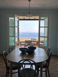 uma mesa de jantar com vista para o oceano em Villa Il Paradiso Andros em Gavrio