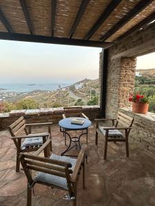 um pátio com uma mesa e cadeiras e uma vista em Villa Il Paradiso Andros em Gavrio