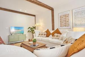 sala de estar con sofá blanco y TV en Apartamento Cervantes, en Santander