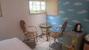 新埔鎮的住宿－霽月山莊，一间设有桌椅的房间,墙上有云彩