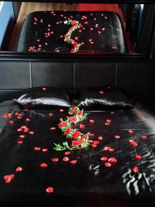 a black bed with red flowers on it at La Love - Love room Marseille in Marseille