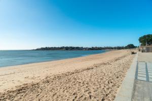 una playa de arena con un muelle y el océano en La Mouette - Appartement à 100m de la plage, en Bénodet