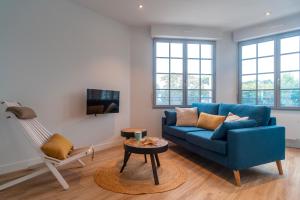 a living room with a blue couch and a chair at La Mouette - Appartement à 100m de la plage in Bénodet