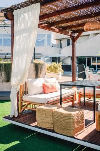 pérgola con sofá y mesa en el patio en Hotel Puerto Sherry, en El Puerto de Santa María