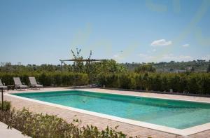 una piscina en un patio con sillas alrededor en Trulli&Dimore - Casale del Vento, en Faccia di Trippa di Monte