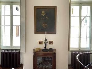 a room with two windows and a painting on the wall at Il Convento Ancient Apartment with private garden in Bellagio