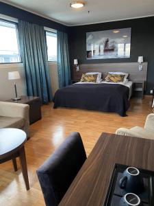 1 dormitorio con 1 cama y sala de estar en Ågotnes Hotell & Motell, en Ågotnes