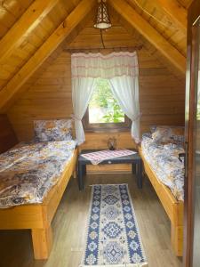 a room with two beds in a log cabin at Căbănuță la Munte cu Piscină in Bistra