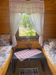 a room with two beds and a window at Căbănuță la Munte cu Piscină in Bistra