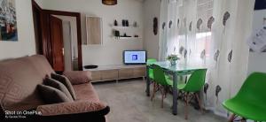 a living room with a table and green chairs at Gasteiz Etxea Il in Vitoria-Gasteiz