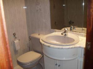 uma casa de banho com um lavatório, um WC e um espelho. em Apartamento 100 m playa, Vilagarcía de Arousa. em Vilagarcía de Arousa