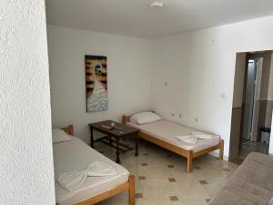 a room with two beds and a table at Apartments Doda in Ulcinj