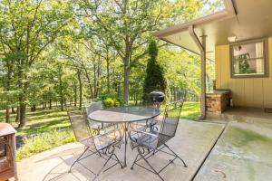 a patio with a table and chairs in front of a house at Home on the hill, nestled in the woods. in Farmington