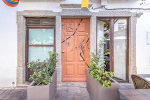 una porta arancione su un edificio con piante in vaso di LODO Suits Ria - Private Room by HD a Faro
