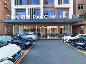 a parking lot with cars parked in front of a hotel at Paco Hotel Guangzhou South Railway Station Panyu Changlong Branch in Guangzhou