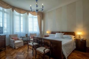 a bedroom with a bed and chairs and windows at Hotel Villa Mabapa in Venice-Lido