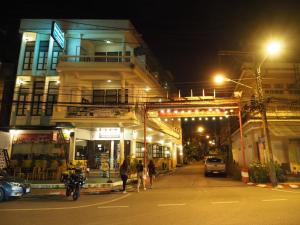 un grupo de personas caminando por una calle por la noche en Thunyaporn Hostel, en Trang