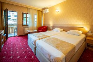 a hotel room with two beds and a window at Sevastokrator Relax & Congress in Arbanasi