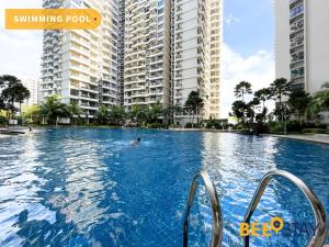 eine Person, die in einem Pool mit hohen Gebäuden schwimmt in der Unterkunft JB SeaView with Balcony Country Garden Danga Bay for 6 Pax in Johor Bahru