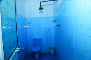 a blue bathroom with a toilet and a shower at White Diamond Resort in Trincomalee